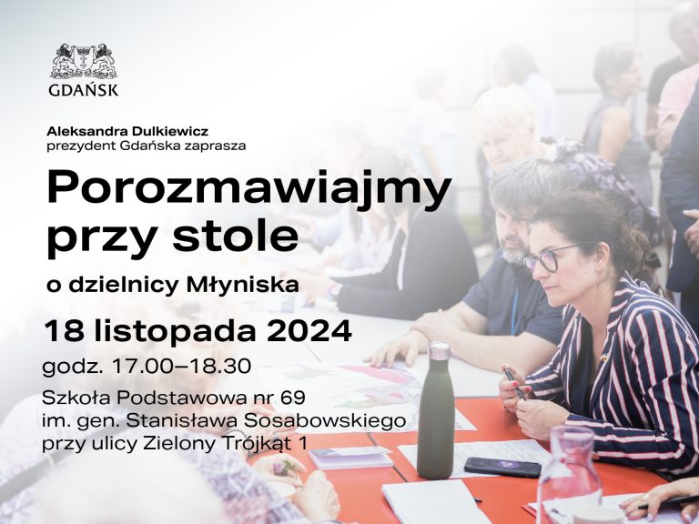 Zgromadzenie mieszkańców Gdańska przy stole, dyskutujących o dzielnicy. Na stole leżą dokumenty. Widać postacie ludzi, w tym prezydent Dulkiewicz. Data i miejsce spotkania podano w treści.